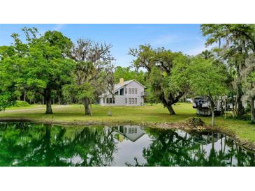 Two story house with a pond and lush green landscape at 1795 Hideaway Ln, Edgewater, FL 32141