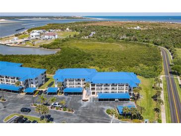 Modern condo building with blue roofs and covered parking, near the water at 2700 N Peninsula Ave # 536, New Smyrna Beach, FL 32169