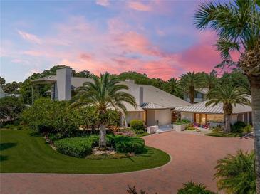 Luxury home with a metal roof, landscaping, and a brick driveway at 1006 S Riverside Dr, Edgewater, FL 32132