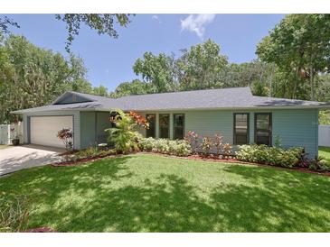 Ranch-style home with a large yard and attached garage at 1319 Orange Tree Dr, Edgewater, FL 32132