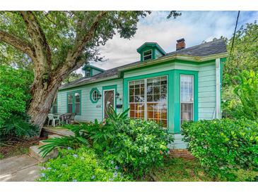 Charming light green house with mature landscaping and large tree at 1206 S Riverside Dr, New Smyrna Beach, FL 32168