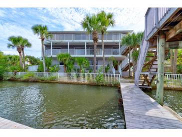 Two-story waterfront home with private dock and lush landscaping at 824 Eel Ave, New Smyrna Beach, FL 32169