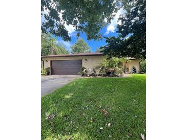 House exterior with a brown garage door and landscaping at 2503 Woodland Dr, Edgewater, FL 32141