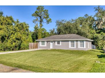 Newly constructed grey house with white accents, and a grassy lawn at 1004 W 7Th St, New Smyrna Beach, FL 32168