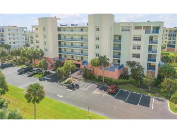Multi-story condo building with parking and tropical landscaping at 5300 S Atlantic Ave # 15-601, New Smyrna Beach, FL 32169