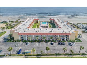 Aerial view of an oceanfront building with parking and pool at 3801 S Atlantic Ave # 307, New Smyrna Beach, FL 32169