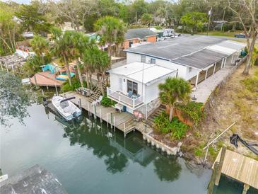 Waterfront home with dock, boat lift, and lush landscaping at 130 Indian Creek Rd, Oak Hill, FL 32759