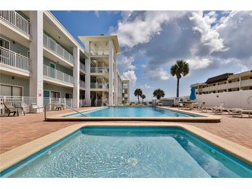 Community pool and spa with surrounding patio and lounge chairs at 3509 S Atlantic Ave # 108 & 109, New Smyrna Beach, FL 32169