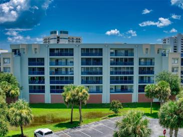 Condo building exterior with palm trees and parking lot at 5300 S Atlantic Ave # 1-203, New Smyrna Beach, FL 32169