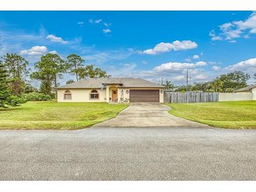 Single-story house with a brown garage door and well-maintained lawn at 1331 Umbrella Tree Dr, Edgewater, FL 32132