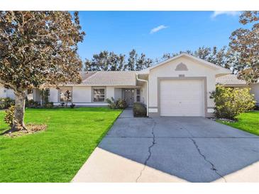 Single-story home with a two-car garage and well-maintained lawn at 3313 Celena Cir, St Cloud, FL 34769