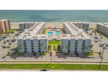 Aerial view of a beachfront condo complex with two buildings, pools, and parking at 4151 S Atlantic Ave # 112, New Smyrna Beach, FL 32169