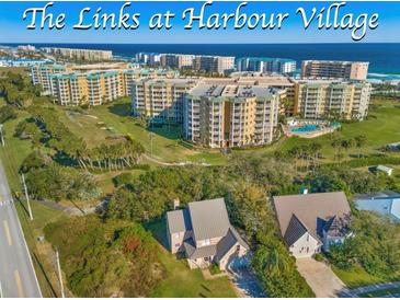 Aerial view of coastal community, featuring oceanfront building and lush landscaping at 4670 Links Village Dr # C402, Ponce Inlet, FL 32127
