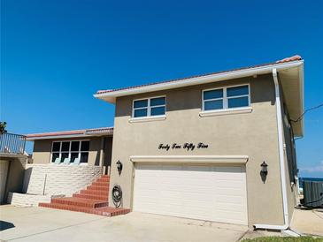 Tan two-story house with attached garage and ocean view at 4255 S Atlantic Ave, Port Orange, FL 32127