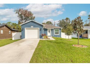 Newly built home with a blue exterior, white garage door, and landscaped lawn at 439 Palmetto St, Edgewater, FL 32132