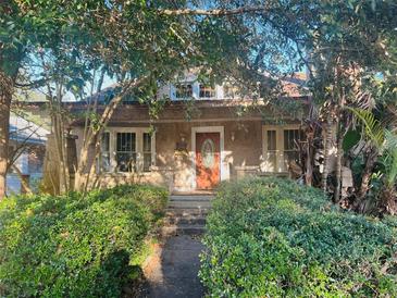 Charming house with a classic facade, steps, and lush landscaping at 307 S Orange St, New Smyrna Beach, FL 32168