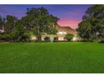 Stunning two-story home with manicured lawn and mature trees at 10980 Jim Edwards Rd, Haines City, FL 33844