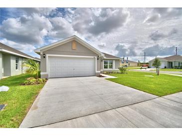 One-story house with a garage and landscaping at 1278 Tagliamento Ln, Haines City, FL 33844