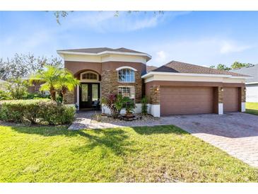 Single-story home with a two-car garage and landscaped yard at 306 Alexandria Place Dr, Apopka, FL 32712