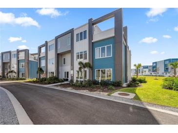 Modern townhome community with teal and gray buildings at 7740 Sandy Ridge Dr # 132, Reunion, FL 34747