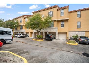 Exterior view of townhouses with parking and lush landscaping at 6119 Metrowest Blvd # 106, Orlando, FL 32835