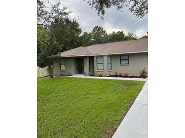 Newly renovated home with gray exterior, modern landscaping, and a welcoming front entrance at 19 Pine Court Loop, Ocala, FL 34472