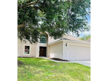Two-story house with a three car garage and large tree at 1856 Emily Dr, Winter Haven, FL 33884