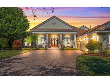 Elegant home exterior with brick driveway and lush landscaping at 6443 Cartmel Ln, Windermere, FL 34786