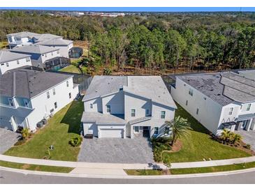 Two-story house with attached garage and landscaping, in a neighborhood, aerial view at 1758 Oak Blossom Dr, Davenport, FL 33837