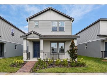 Two-story house with gray siding and a blue door at 4625 Cross Prairie Pkwy, Saint Cloud, FL 34772