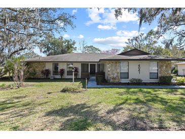 Ranch style home with stone facade and landscaped lawn at 4041 Yacht Ct, Winter Park, FL 32792