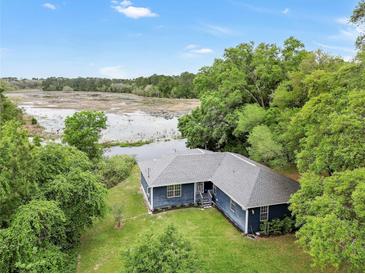 Aerial view of a charming ranch house with a pond in the backyard at 10 Locust Run Crse, Ocala, FL 34472