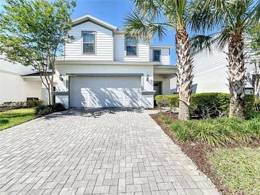 Two-story house with gray brick driveway and lush landscaping at 8914 Zurich Ln, Kissimmee, FL 34747