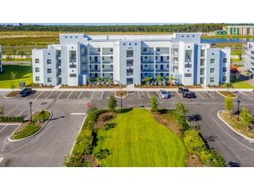 Modern apartment building with ample parking and green space at 4731 Clock Tower Dr # 101, Kissimmee, FL 34746