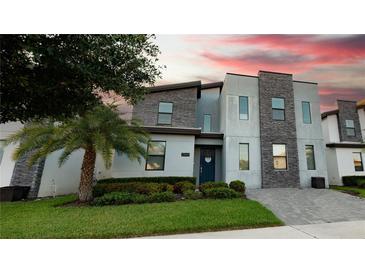 Modern three-story home with stone exterior and landscaping at 2965 Fable St, Kissimmee, FL 34746