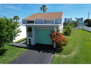 Charming light-green garage door with landscaping and driveway at 59 Chippingwood Ln, Ormond Beach, FL 32176