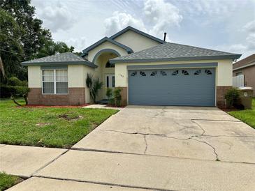 House exterior featuring a two-car garage and landscaping at 165 Seneca Point Trl, Kissimmee, FL 34746