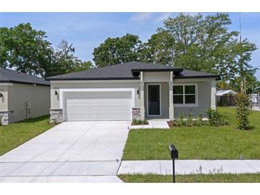 Newly constructed one-story home with a white garage door and landscaped lawn at 2860 Lingo Ln, Orlando, FL 32822