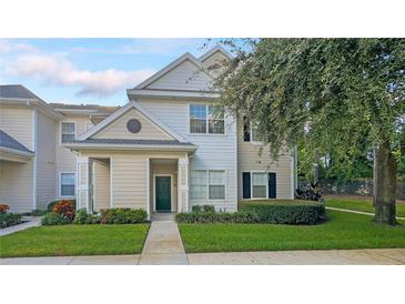 Two-story townhome with light beige siding and landscaping at 200 Southern Pecan Cir # 105, Winter Garden, FL 34787