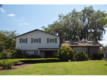 Two-story house with brick and siding, landscaping, and a large yard at 1879 Lake Emma Rd, Longwood, FL 32750