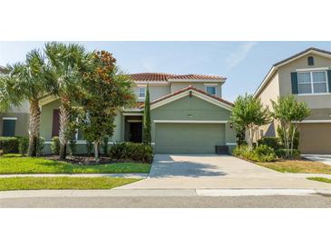 Two-story home with a two-car garage and landscaping at 7049 Oakwood St, Davenport, FL 33837