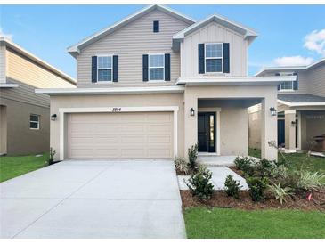 Two-story house with neutral siding and two-car garage at 3672 Sagefield Dr, St Cloud, FL 34773