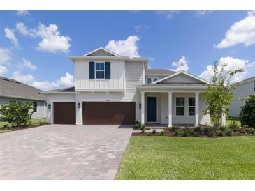 Two-story home with brown double garage doors and a landscaped front yard at 2993 Water Clover Ct, Apopka, FL 32712