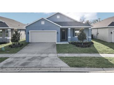 Newly built home with light blue exterior and two car garage at 530 Ellie Ct, Apopka, FL 32703