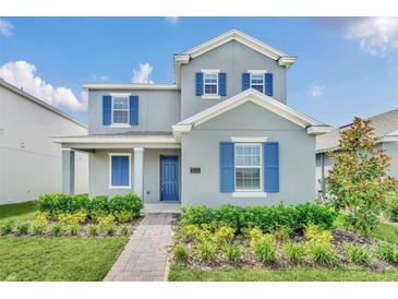 Two-story home with blue shutters and landscaped front yard at 5115 Lake Hamlin Trl, Winter Garden, FL 34787