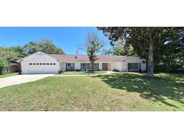 Newly renovated home with a white exterior and landscaping at 1030 Gregory Dr, Maitland, FL 32751