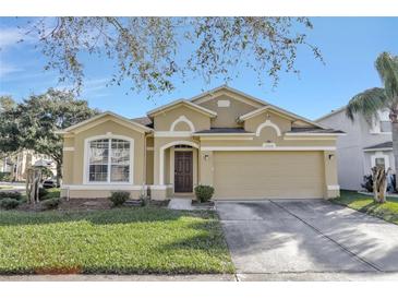 Tan house with 2-car garage, great curb appeal at 2524 Dover Glen Cir, Orlando, FL 32828