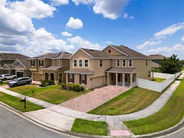 Two-story house with a brick driveway and manicured lawn at 1508 Caterpillar St, St Cloud, FL 34771