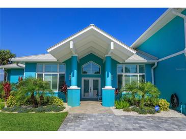 Stunning teal home with a grand entrance and manicured landscaping at 1112 N Peninsula Ave, New Smyrna Beach, FL 32169