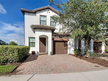 Two-story home with a brick driveway and landscaping at 1358 Royal St George Blvd, Davenport, FL 33896